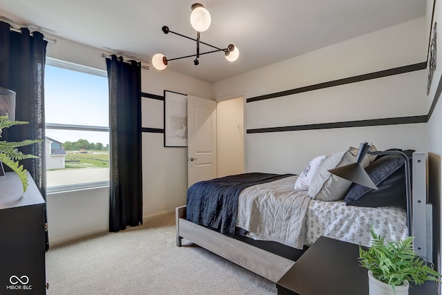 carpeted bedroom featuring an inviting chandelier