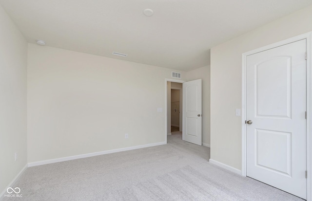 unfurnished bedroom featuring visible vents, light carpet, and baseboards