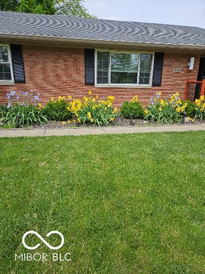 view of side of home with a yard