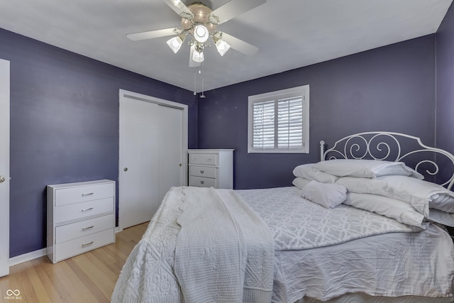 bedroom with ceiling fan, light hardwood / wood-style flooring, and a closet