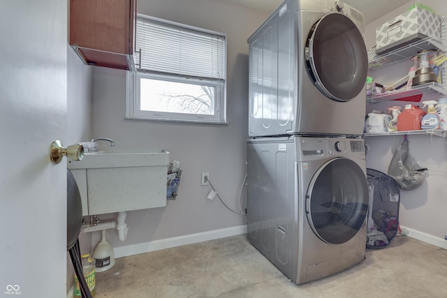 washroom with stacked washer / dryer, sink, and cabinets