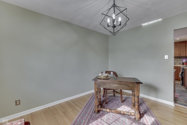 office area featuring a notable chandelier and light wood-type flooring