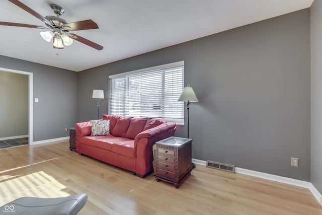 living room with ceiling fan and light hardwood / wood-style flooring