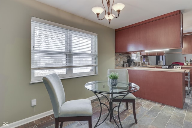 dining space featuring sink and an inviting chandelier