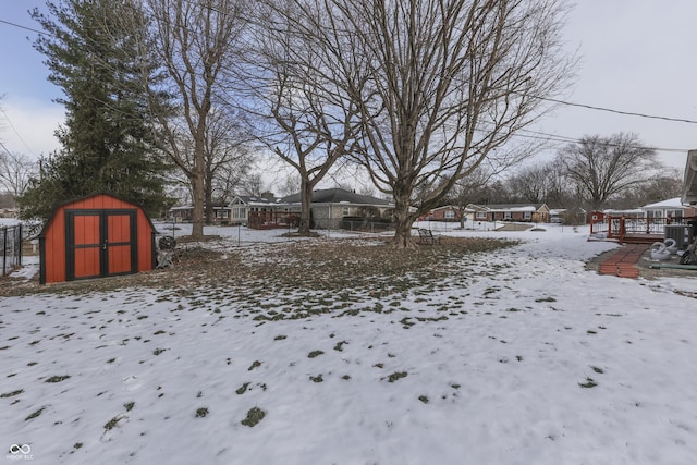 yard layered in snow with a storage unit