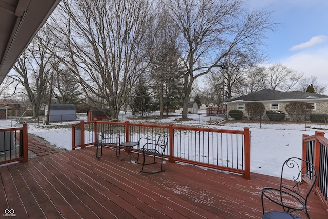 snow covered deck featuring a storage unit