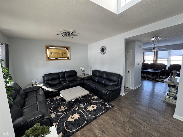 living room with ceiling fan, dark hardwood / wood-style floors, and a textured ceiling