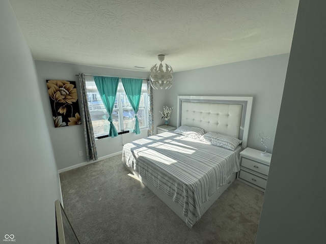 carpeted bedroom featuring a chandelier and a textured ceiling