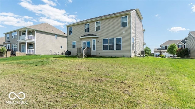 rear view of house with a lawn and central AC