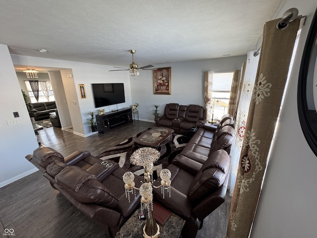 living room with dark wood-type flooring, a wealth of natural light, and a textured ceiling