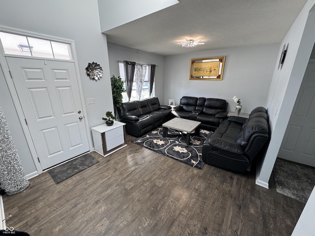 living room with dark hardwood / wood-style floors and a textured ceiling