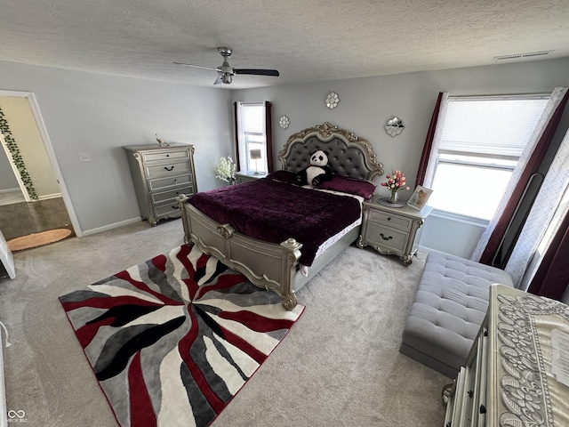 bedroom featuring ceiling fan, a textured ceiling, and light carpet