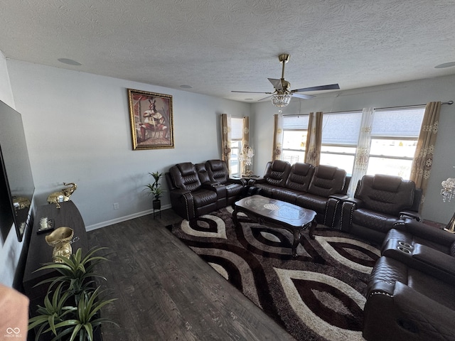 living room with dark wood-type flooring, a textured ceiling, and ceiling fan