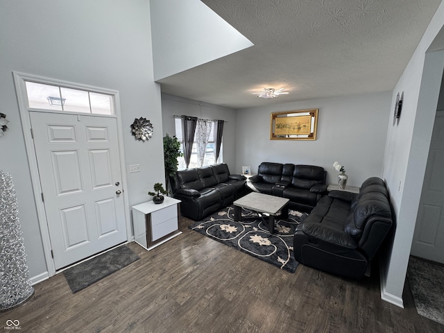 living room with a textured ceiling and dark hardwood / wood-style flooring