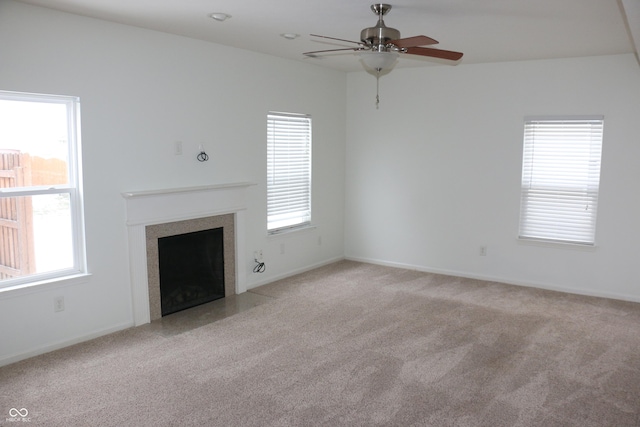 unfurnished living room with plenty of natural light, light colored carpet, and ceiling fan