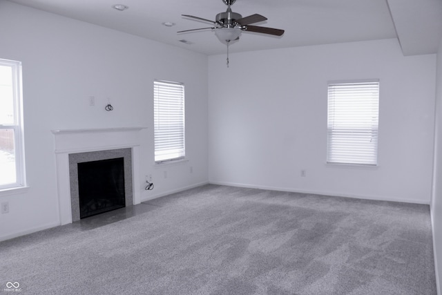 unfurnished living room with light carpet, ceiling fan, and a healthy amount of sunlight