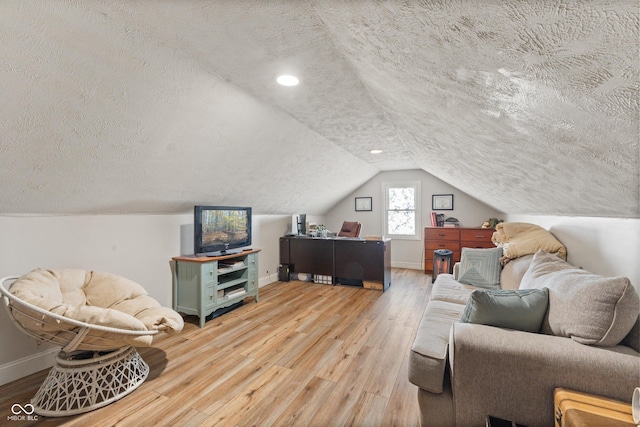 living room with lofted ceiling, hardwood / wood-style flooring, and a textured ceiling