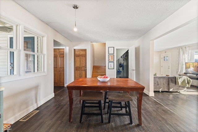 dining room with dark hardwood / wood-style flooring and a textured ceiling