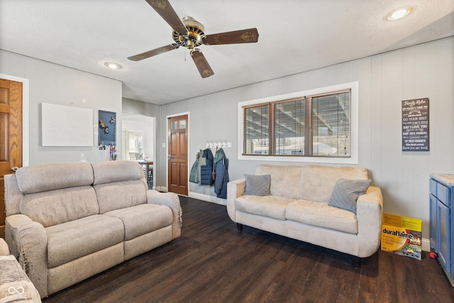 living room with ceiling fan, dark hardwood / wood-style flooring, and a textured ceiling