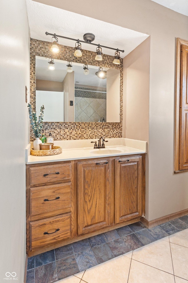 bathroom featuring vanity, rail lighting, a textured ceiling, and backsplash