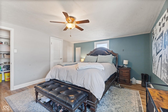 bedroom with hardwood / wood-style flooring, a textured ceiling, and ceiling fan