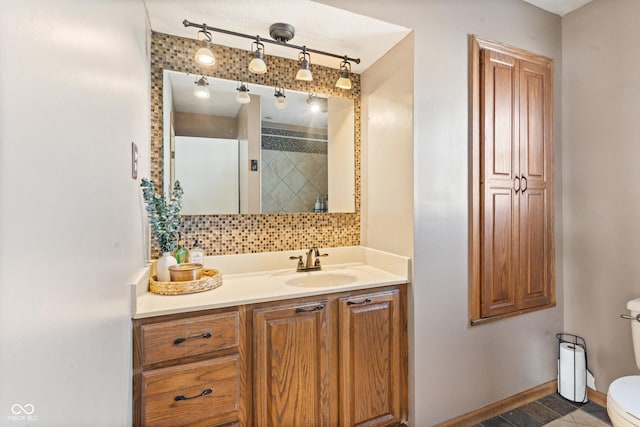 bathroom with vanity, toilet, a shower, and backsplash