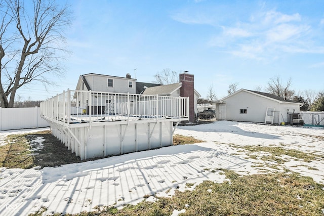 snow covered house with a deck