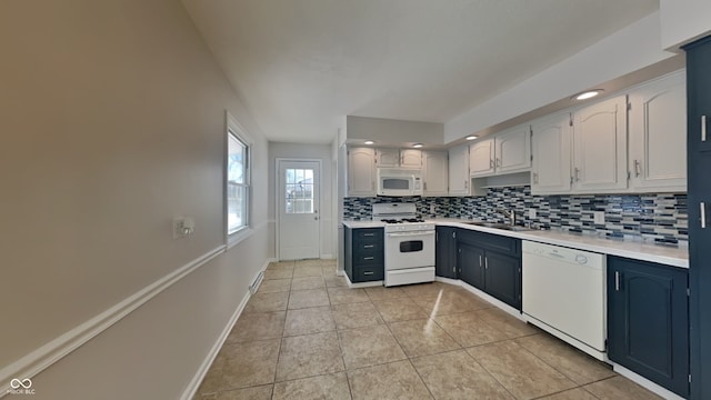 kitchen featuring sink, backsplash, white cabinetry, light tile patterned floors, and white appliances