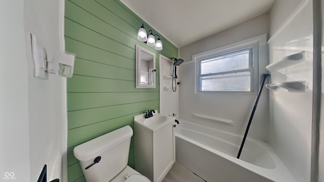 full bathroom featuring bathtub / shower combination, toilet, vanity, and wooden walls