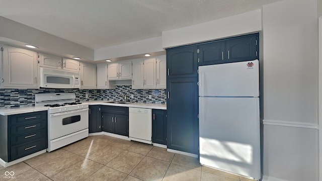 kitchen with white appliances, white cabinetry, light tile patterned floors, decorative backsplash, and sink