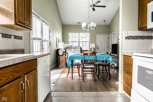 kitchen with pendant lighting, a wealth of natural light, white appliances, and light tile patterned floors