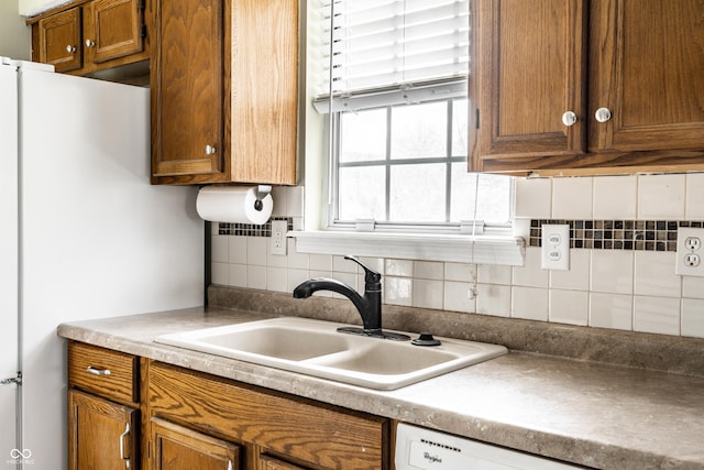 kitchen with dishwasher, sink, and backsplash