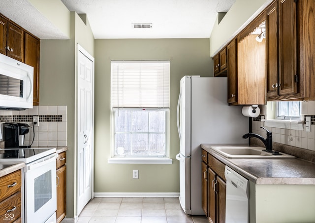 kitchen featuring white appliances, sink, decorative backsplash, and light tile patterned floors