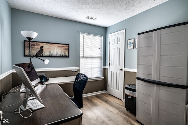 office area with light hardwood / wood-style flooring and a textured ceiling