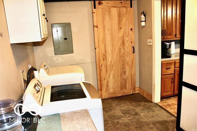 laundry area featuring electric panel and a barn door