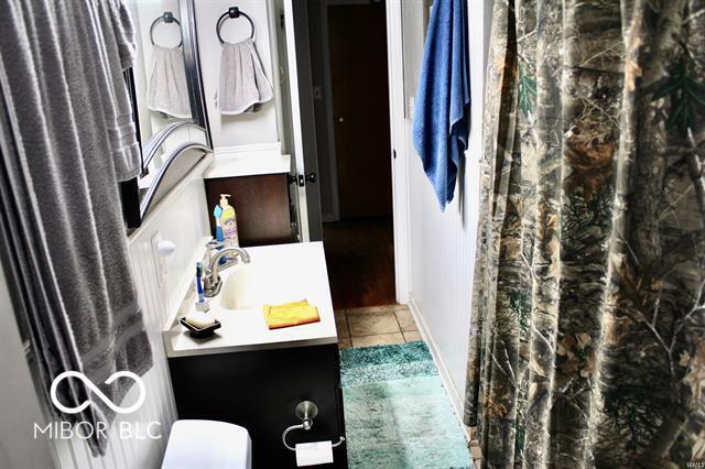 bathroom featuring toilet, tile patterned floors, and vanity