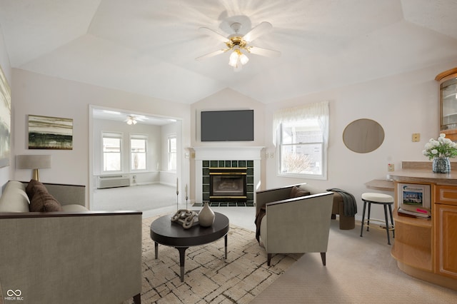 living room with ceiling fan, a wealth of natural light, light carpet, and a tiled fireplace