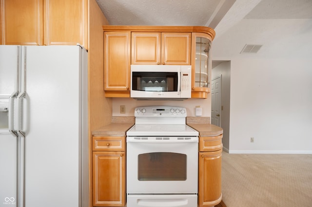 kitchen featuring white appliances, light carpet, and a textured ceiling