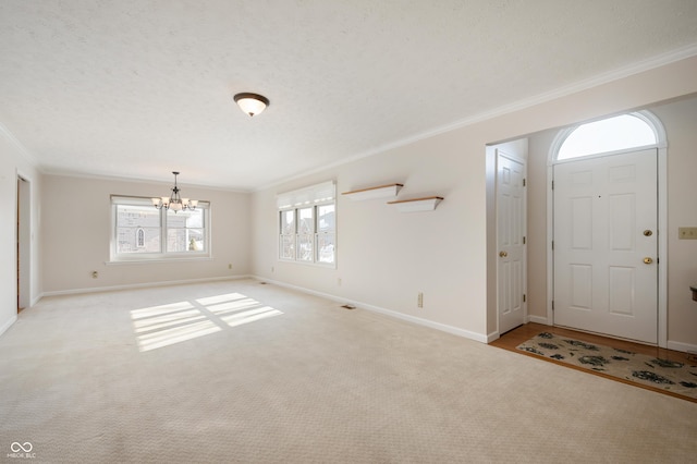 carpeted foyer with a textured ceiling, crown molding, and a notable chandelier