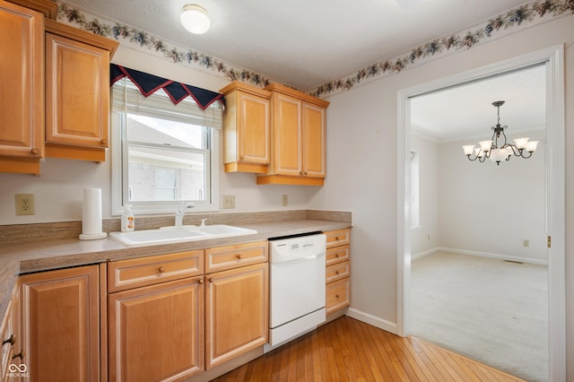 kitchen with pendant lighting, white dishwasher, sink, light hardwood / wood-style floors, and a chandelier