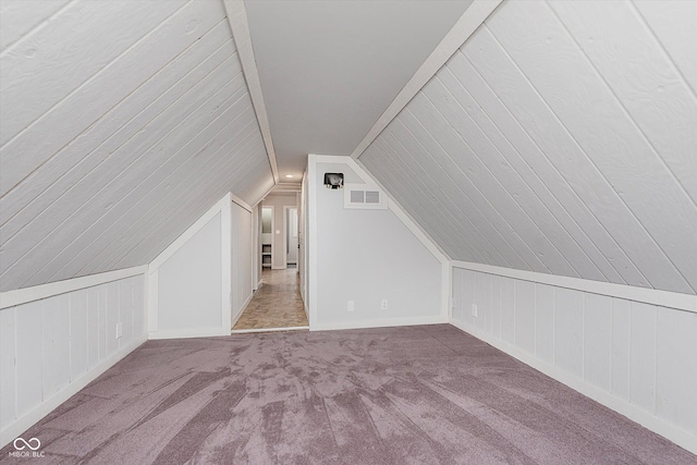 bonus room featuring lofted ceiling, carpet flooring, and visible vents