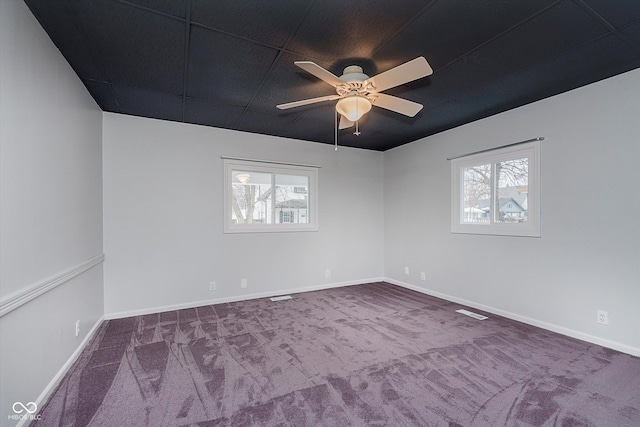 carpeted spare room with a ceiling fan, a healthy amount of sunlight, and baseboards