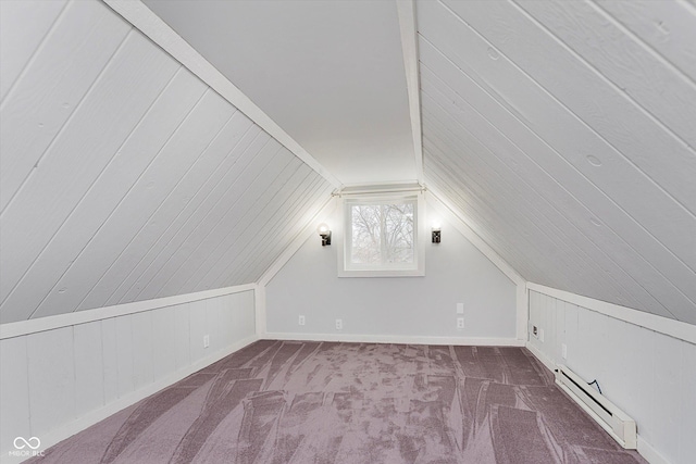 bonus room with lofted ceiling, a baseboard heating unit, and dark colored carpet