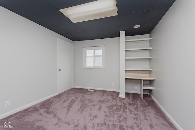 unfurnished bedroom with a paneled ceiling and carpet flooring