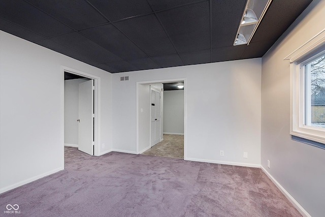 carpeted spare room featuring a paneled ceiling