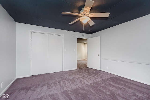 unfurnished bedroom featuring a ceiling fan, a closet, carpet flooring, and baseboards