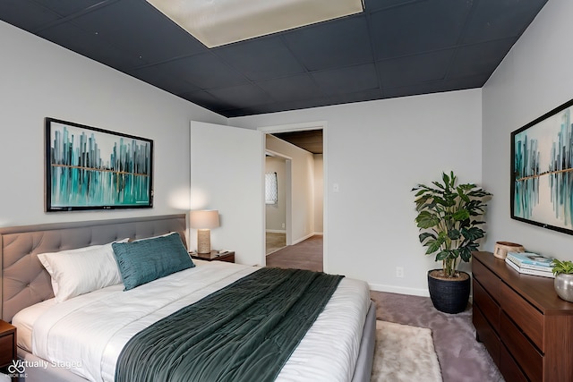 bedroom with carpet floors and a paneled ceiling