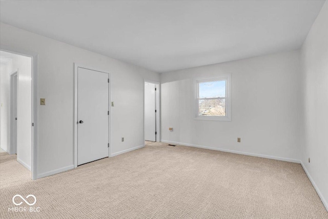 unfurnished bedroom with light carpet and baseboards