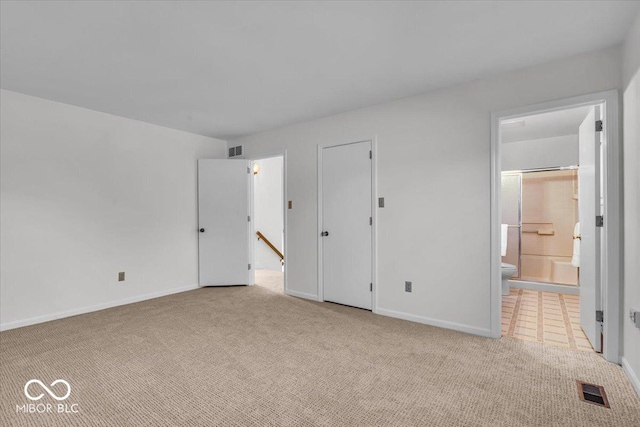 unfurnished bedroom with visible vents, baseboards, carpet, and ensuite bath