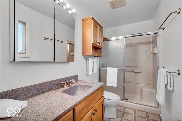 bathroom with a shower with door, toilet, and vanity